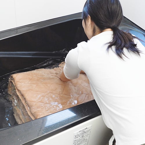 水を張った浴槽で押し洗い