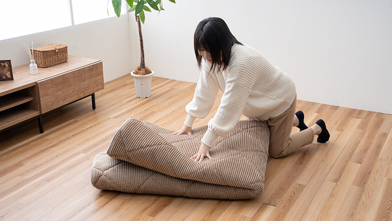 ラグをたたむ女性